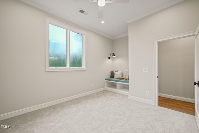 interior space featuring ceiling fan, carpet floors, and ornamental molding