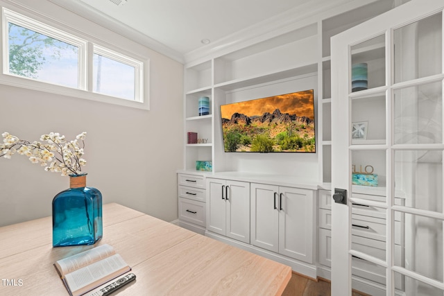 home office featuring wood-type flooring and crown molding