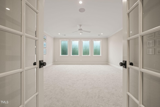 spare room with ceiling fan, crown molding, and carpet