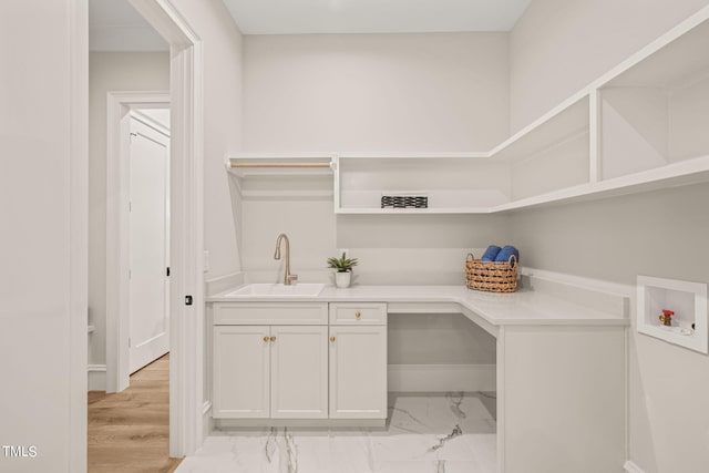 laundry area with washer hookup, cabinets, light hardwood / wood-style floors, and sink