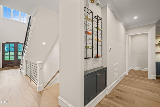 corridor featuring light wood-type flooring and crown molding