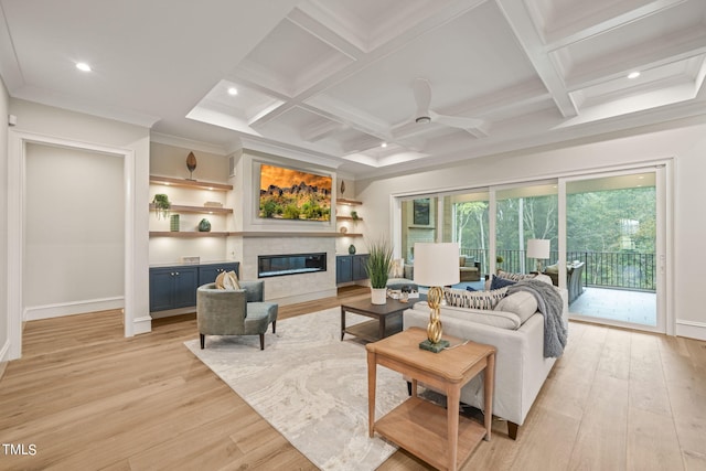 living room featuring ceiling fan, beam ceiling, light hardwood / wood-style flooring, coffered ceiling, and a tile fireplace