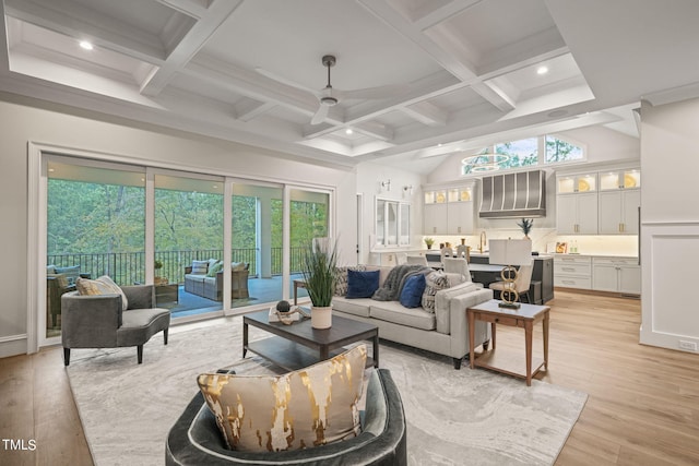 living room featuring a healthy amount of sunlight, coffered ceiling, beam ceiling, and light hardwood / wood-style flooring