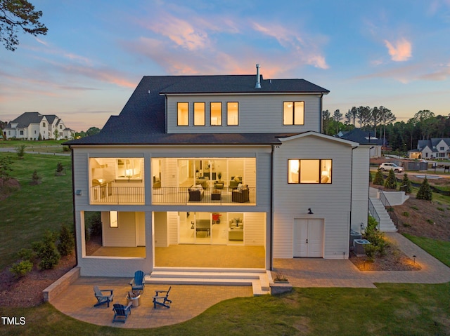 back of property featuring a balcony, a yard, and a patio