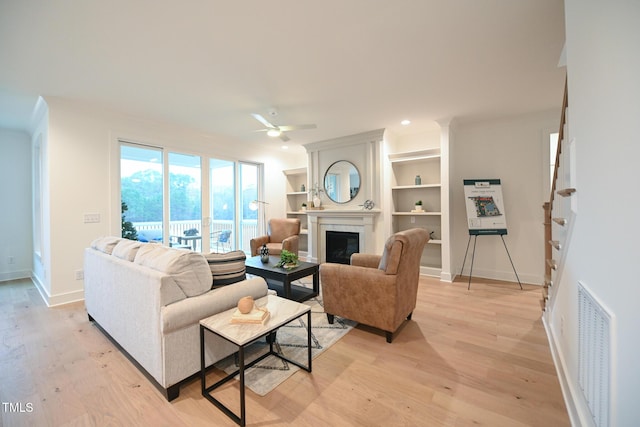 living room with ceiling fan and light hardwood / wood-style flooring