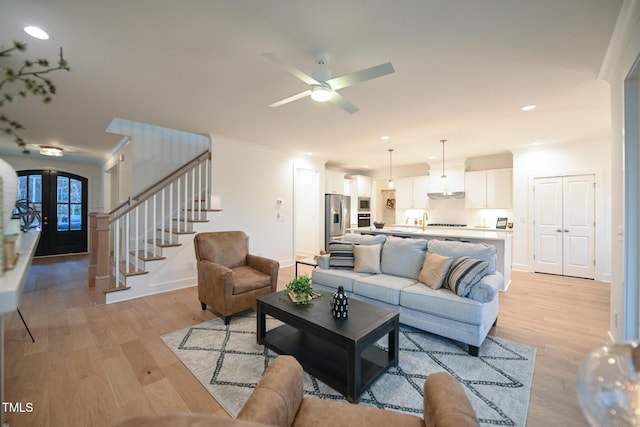 living room featuring french doors, light hardwood / wood-style flooring, and ceiling fan