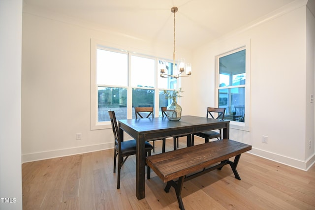 dining room featuring light wood-type flooring, crown molding, and a chandelier