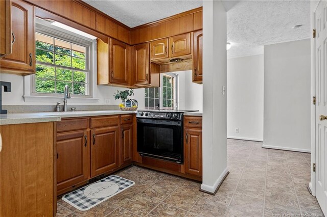 kitchen featuring a textured ceiling, sink, light tile floors, and black range with electric stovetop