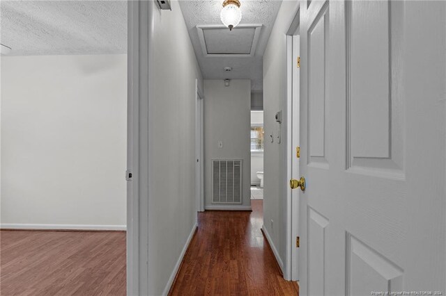 hall with dark hardwood / wood-style flooring and a textured ceiling