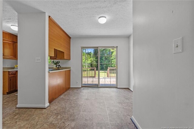 kitchen featuring a textured ceiling and light tile flooring