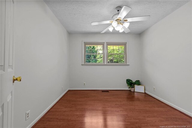 empty room featuring hardwood / wood-style flooring, ceiling fan, and a textured ceiling