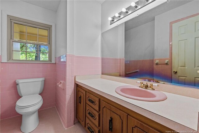 bathroom with tile walls, tile floors, and toilet