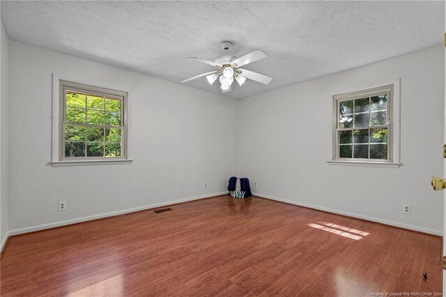 spare room featuring a textured ceiling, ceiling fan, and hardwood / wood-style flooring