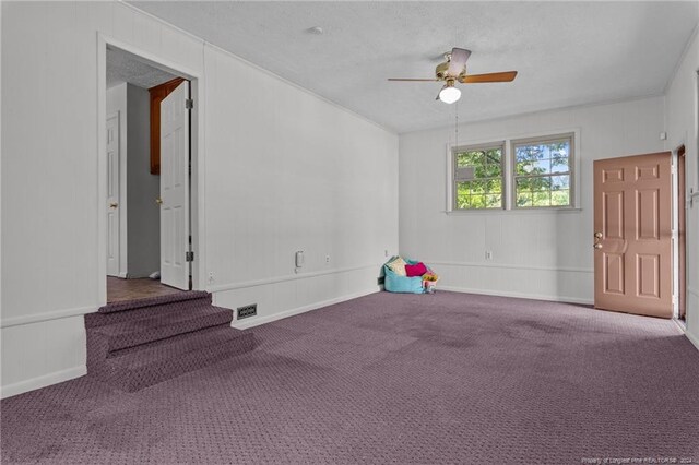 carpeted empty room with a textured ceiling and ceiling fan