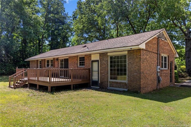 ranch-style house with a deck and a front lawn