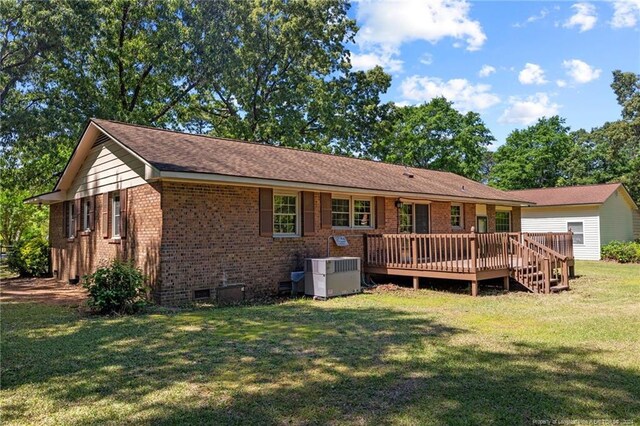 back of house featuring a deck, a yard, and central AC