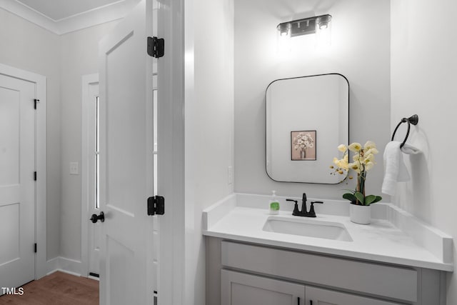 bathroom featuring ornamental molding, vanity, and hardwood / wood-style floors