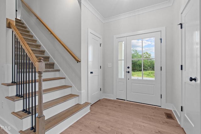 entrance foyer with light hardwood / wood-style flooring and ornamental molding