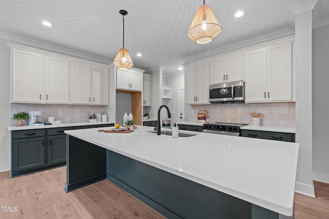 kitchen with white cabinets, stainless steel appliances, and pendant lighting