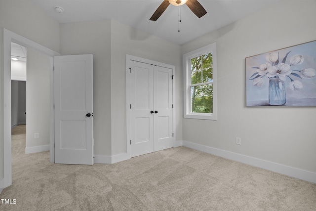 unfurnished bedroom featuring light carpet, ceiling fan, and a closet