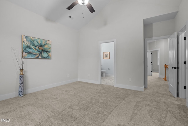 unfurnished bedroom with ceiling fan, light carpet, ensuite bathroom, and high vaulted ceiling