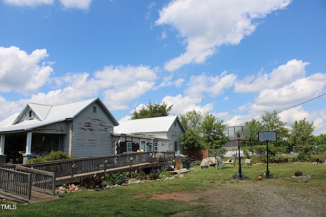 view of home's exterior with a deck and a lawn