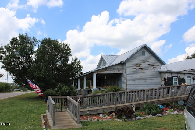 view of front of property featuring a front lawn and a deck