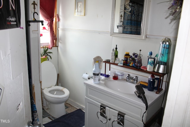 bathroom featuring vanity with extensive cabinet space and toilet