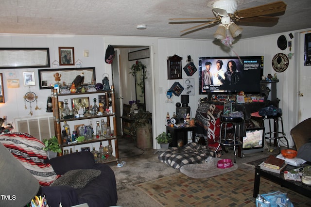 carpeted living room featuring ceiling fan and a textured ceiling