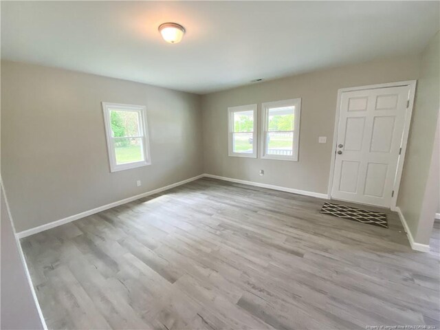 empty room featuring plenty of natural light and hardwood / wood-style flooring