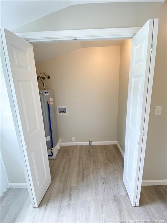 washroom featuring hookup for a washing machine, light hardwood / wood-style floors, and gas water heater