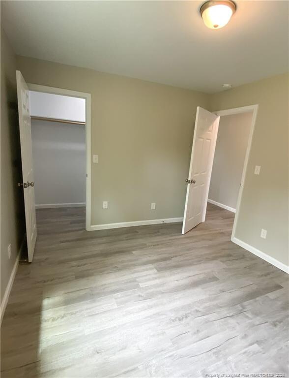 unfurnished bedroom with hardwood / wood-style floors and a closet