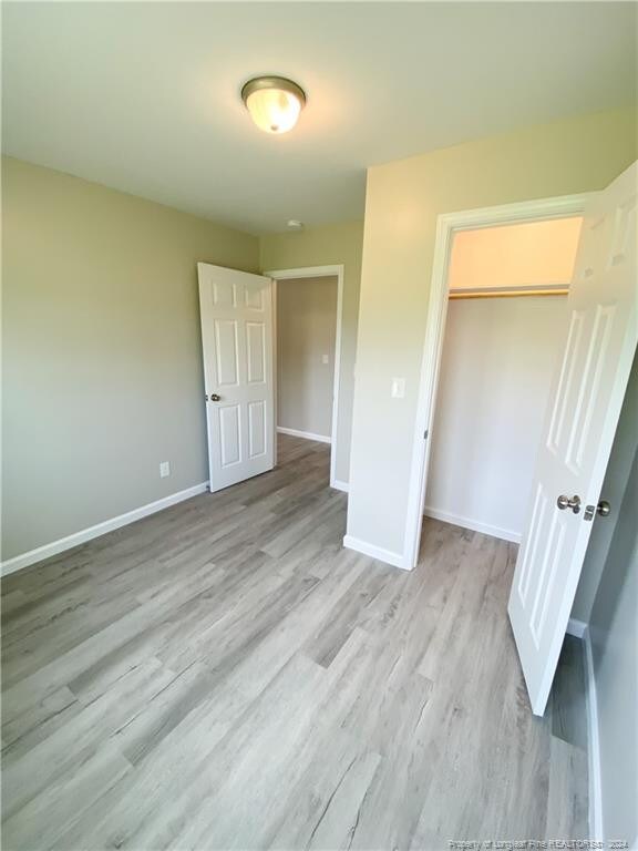 unfurnished bedroom with a closet and hardwood / wood-style flooring