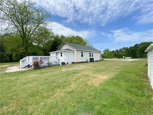 back of property with a yard and a deck