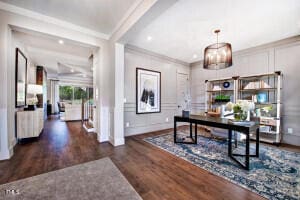 office with dark hardwood / wood-style flooring, an inviting chandelier, and ornamental molding