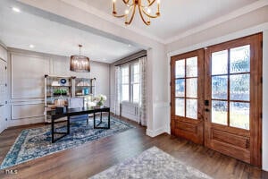 entryway featuring dark hardwood / wood-style floors, french doors, and a chandelier