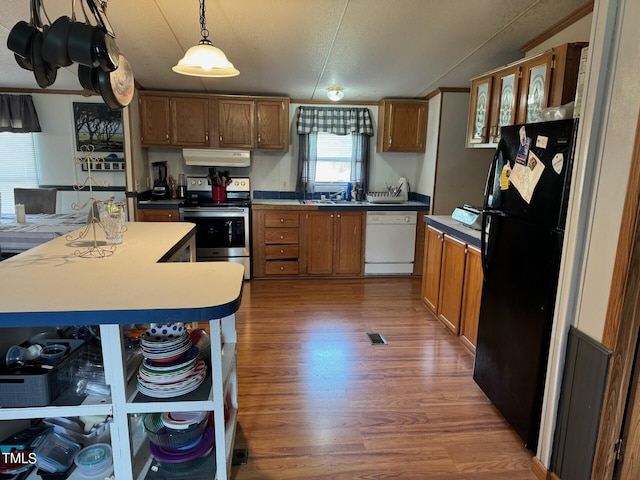 kitchen with black fridge, dishwasher, electric range, hardwood / wood-style flooring, and pendant lighting