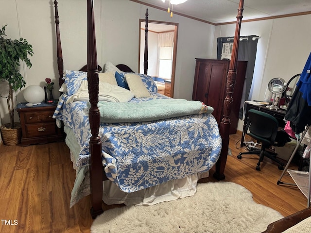 bedroom with wood-type flooring and crown molding