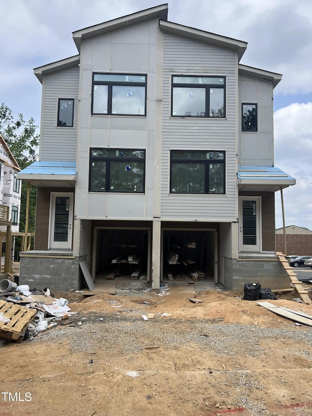 view of front facade with an attached garage and dirt driveway