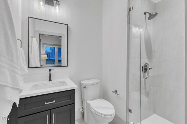 full bath featuring a stall shower, vanity, and toilet