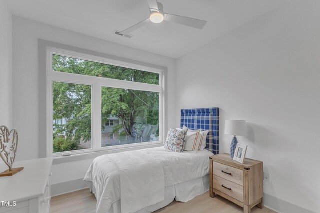 bedroom with multiple windows, visible vents, and light wood-style floors