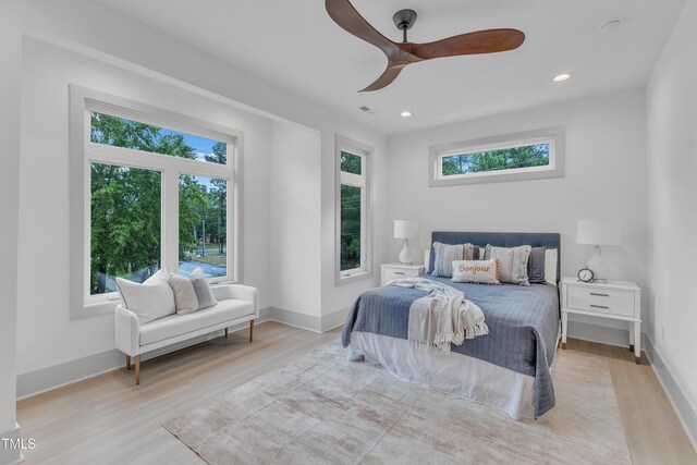 bedroom featuring multiple windows, baseboards, wood finished floors, and recessed lighting