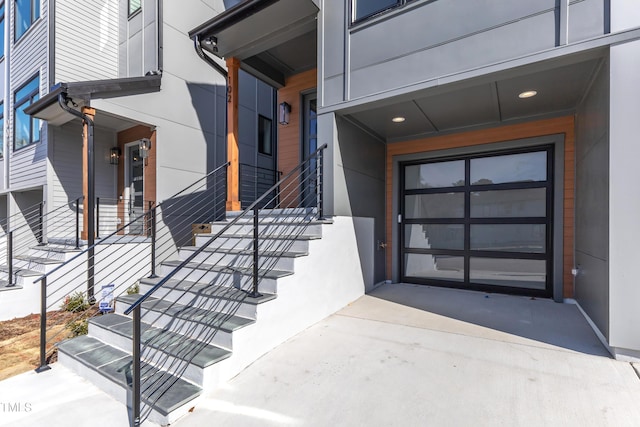 doorway to property with a garage and driveway