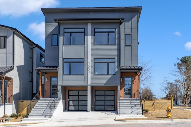 contemporary house with metal roof, a standing seam roof, and an attached garage