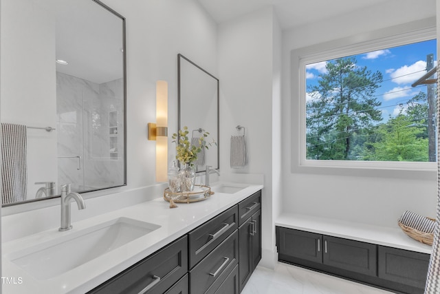 bathroom featuring marble finish floor, double vanity, a sink, and a marble finish shower