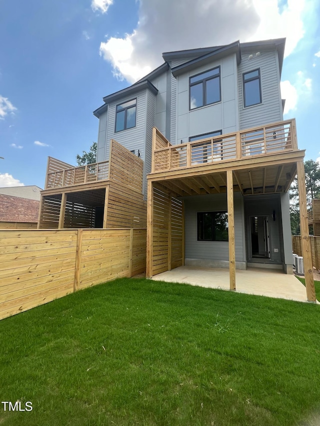 back of house featuring a lawn, a patio area, a fenced backyard, and a balcony