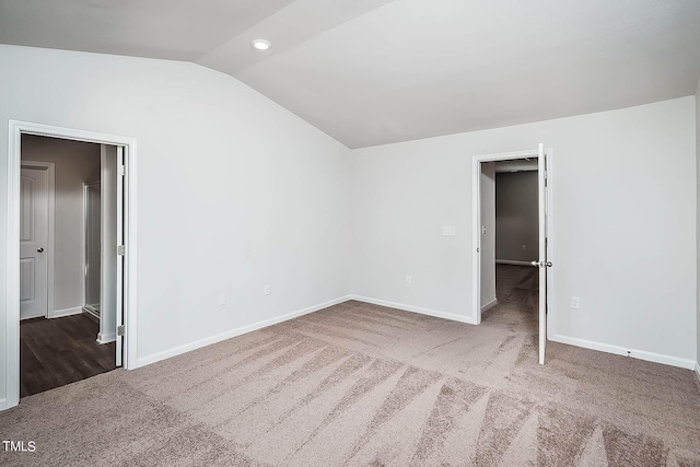 unfurnished bedroom with carpet flooring and lofted ceiling