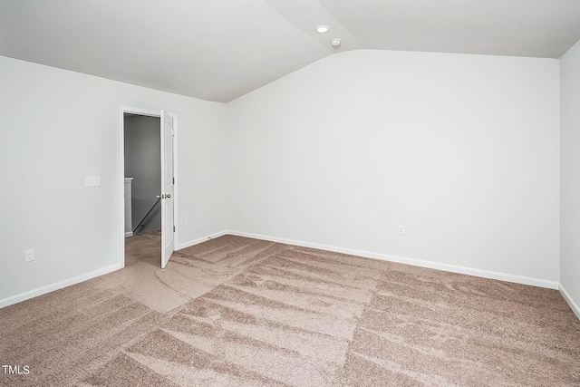 spare room with carpet and vaulted ceiling