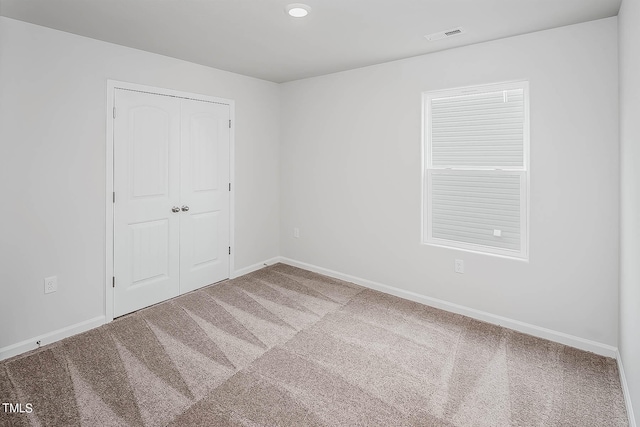 unfurnished bedroom with carpet flooring and a closet