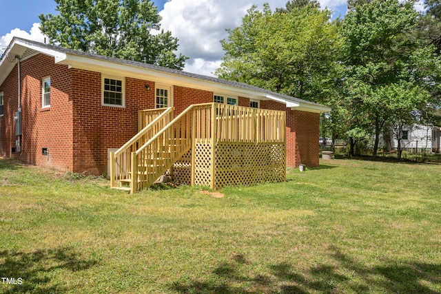 back of house featuring a deck and a lawn